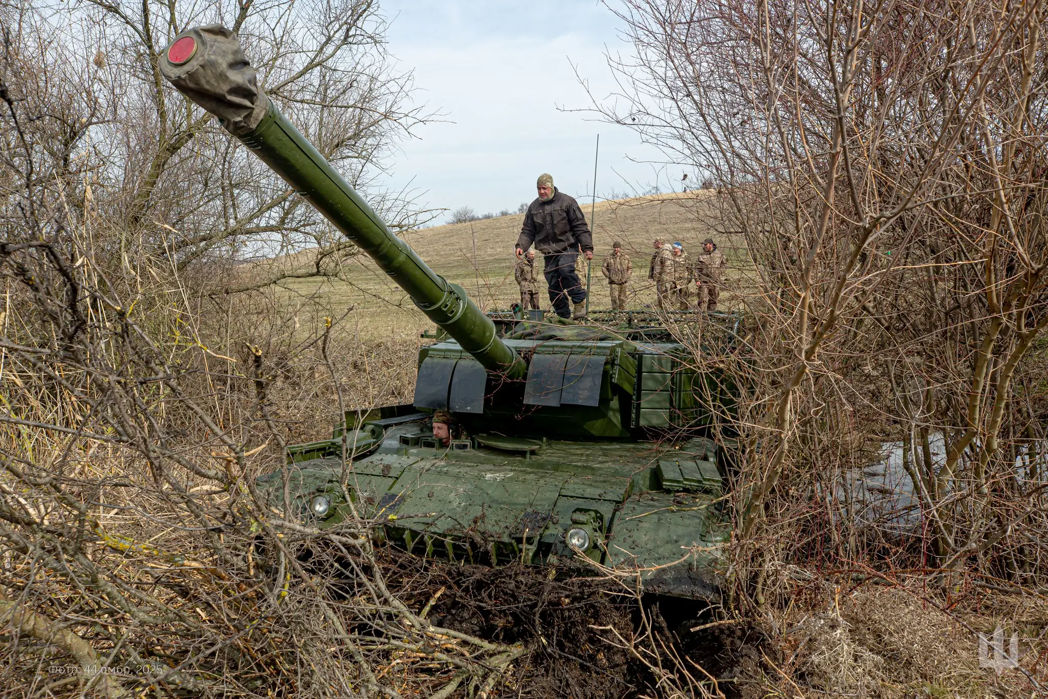 Leopard 1A5 with additional reactive armour and a drone cage drives through a ditch