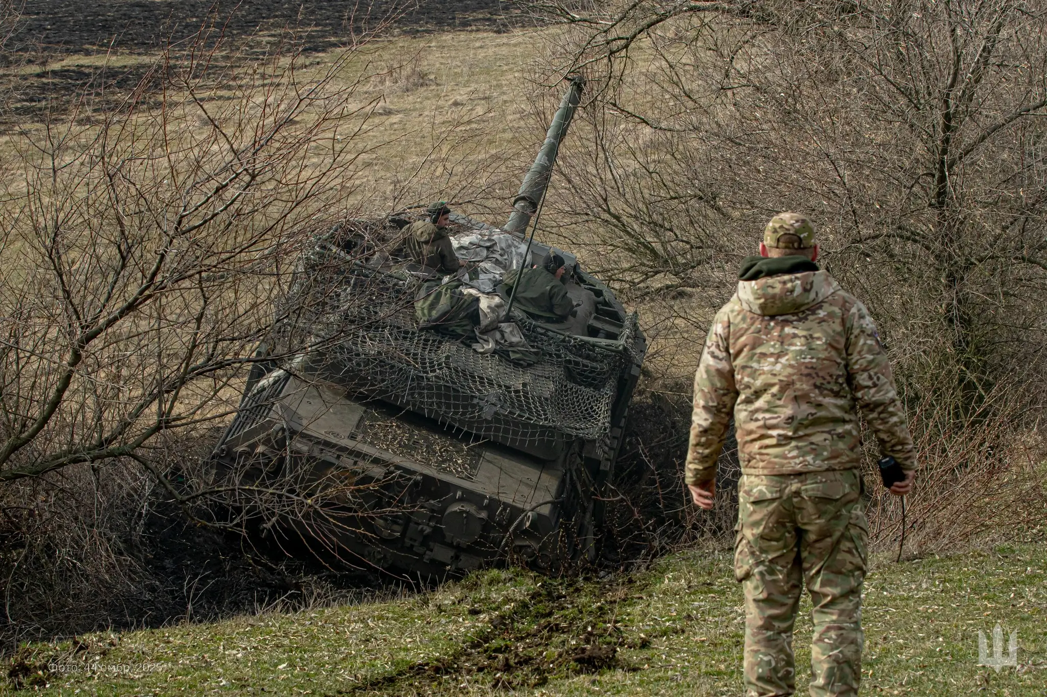 Leopard 1A5 with additional reactive armour and a drone cage drives through a ditch