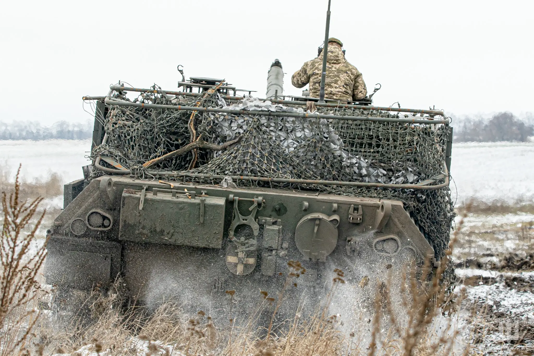 Ukrainian soldier sits on a Leopard 1A5 with a drone cage