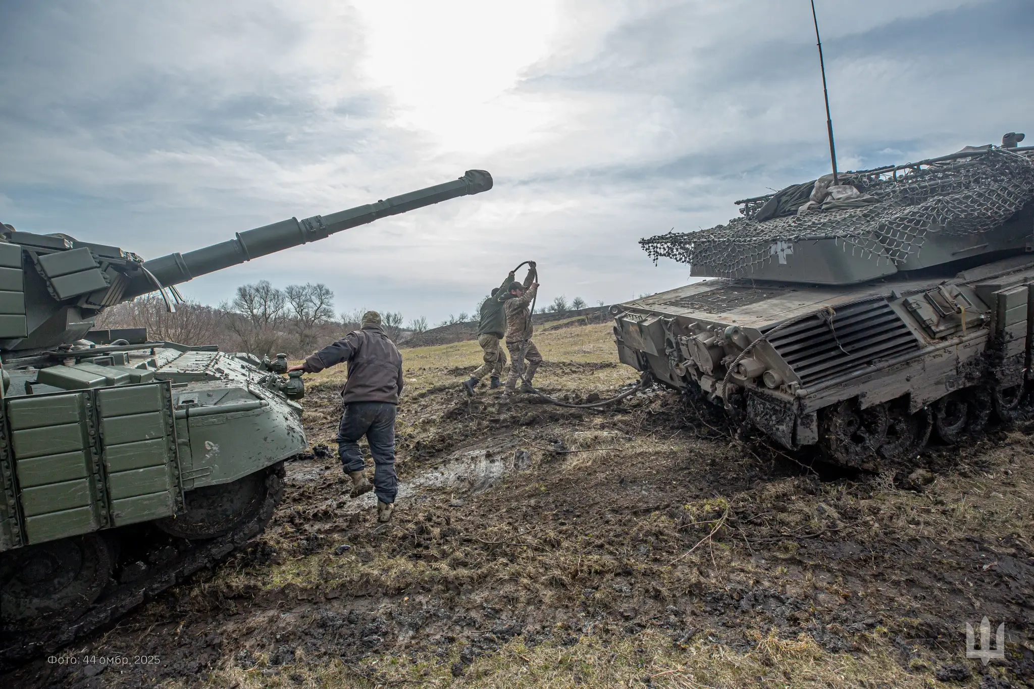Three Ukrainian soldiers with two Leopard 1A5s equipped with reactive armour and a drone cage