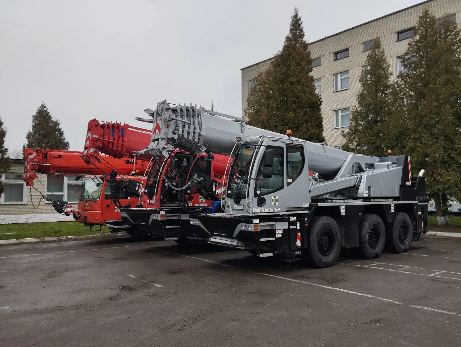 Three heavy-duty cranes stand side by side