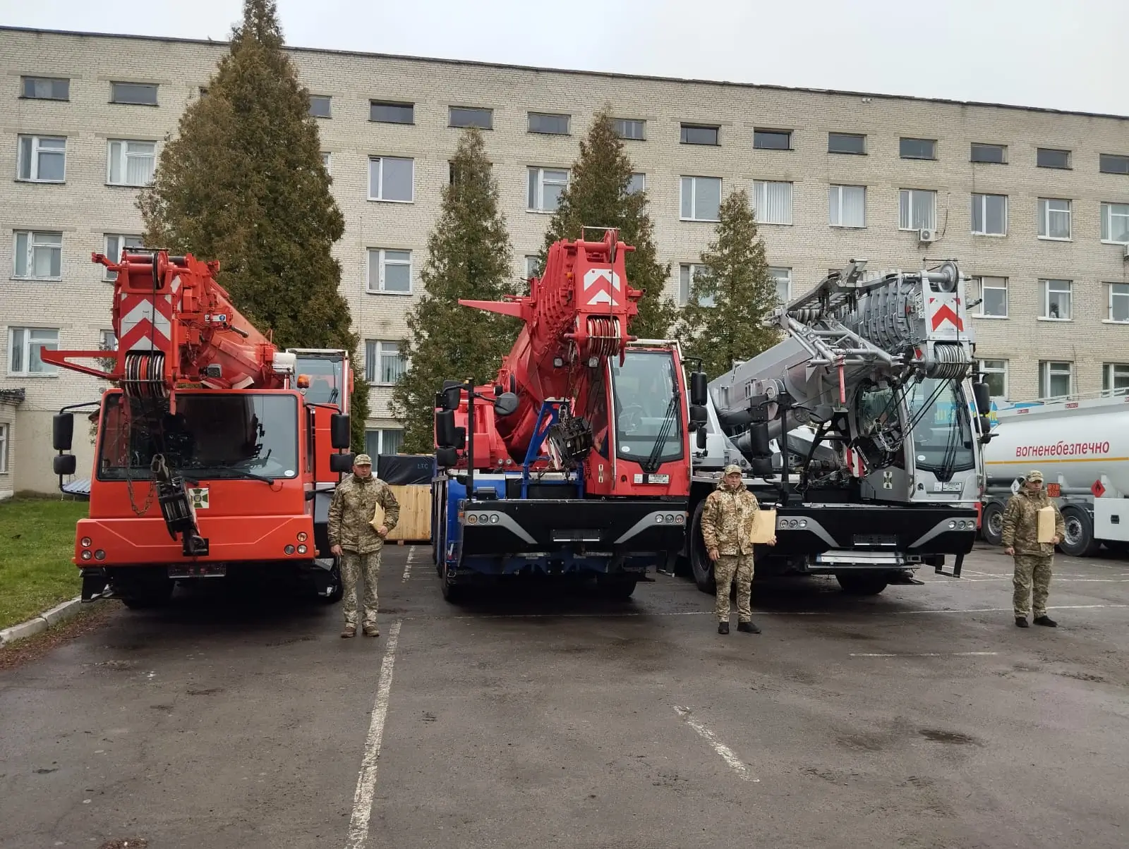 Three heavy-duty cranes stand side by side