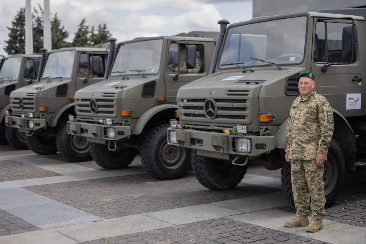 Ukrainian soldier standing next to some of the Mercedes-Benz Unimogs during the handover in Kyiv
