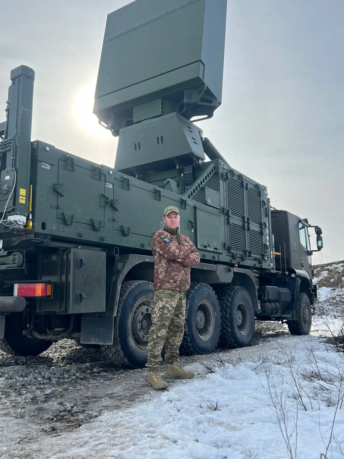 Ukrainian soldier standing in front of an TRML-4D air surveillance radar