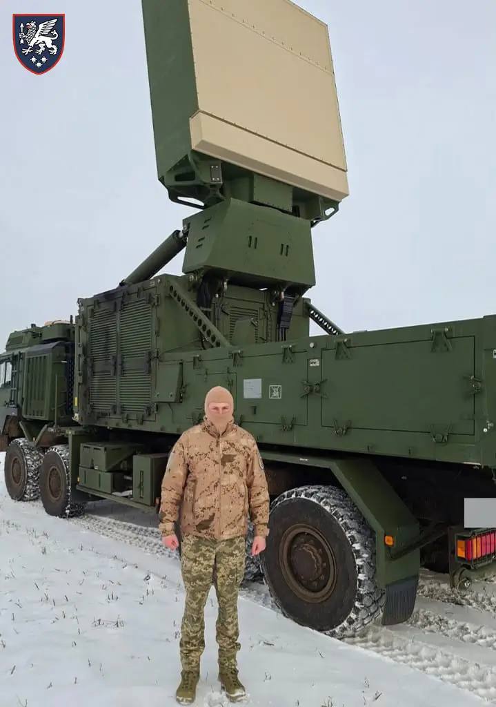 Ukrainian soldier standing in front of an TRML-4D air surveillance radar